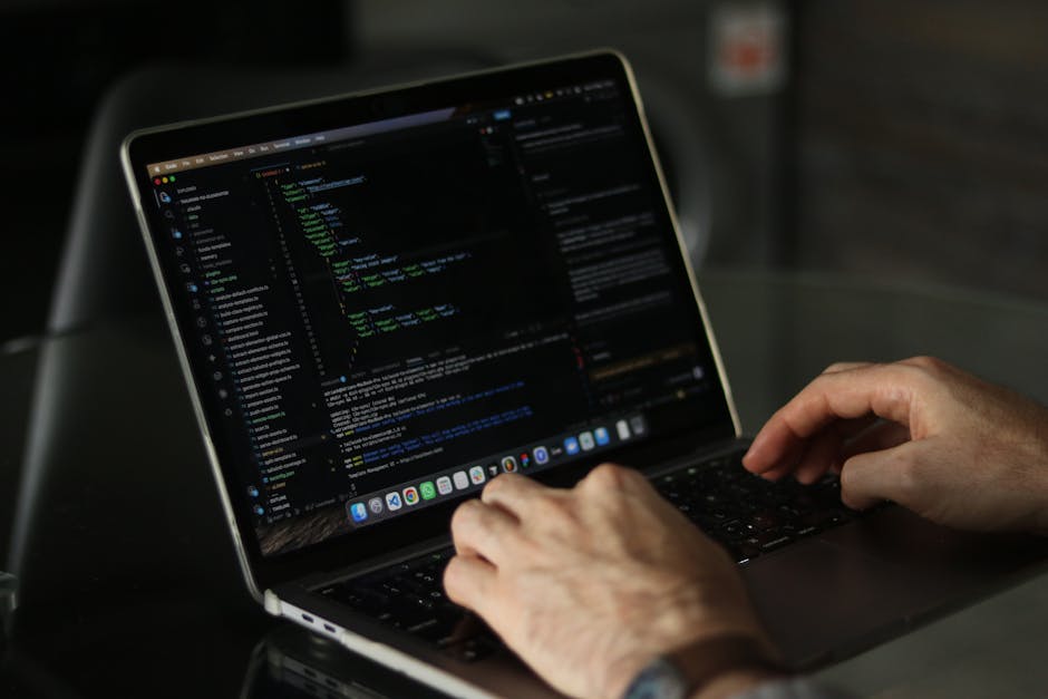 A close-up photograph of a computer screen displaying lines of HTML code, including tags such as <html>, <head>, <title>, and <body>, with a dark background and colorful syntax